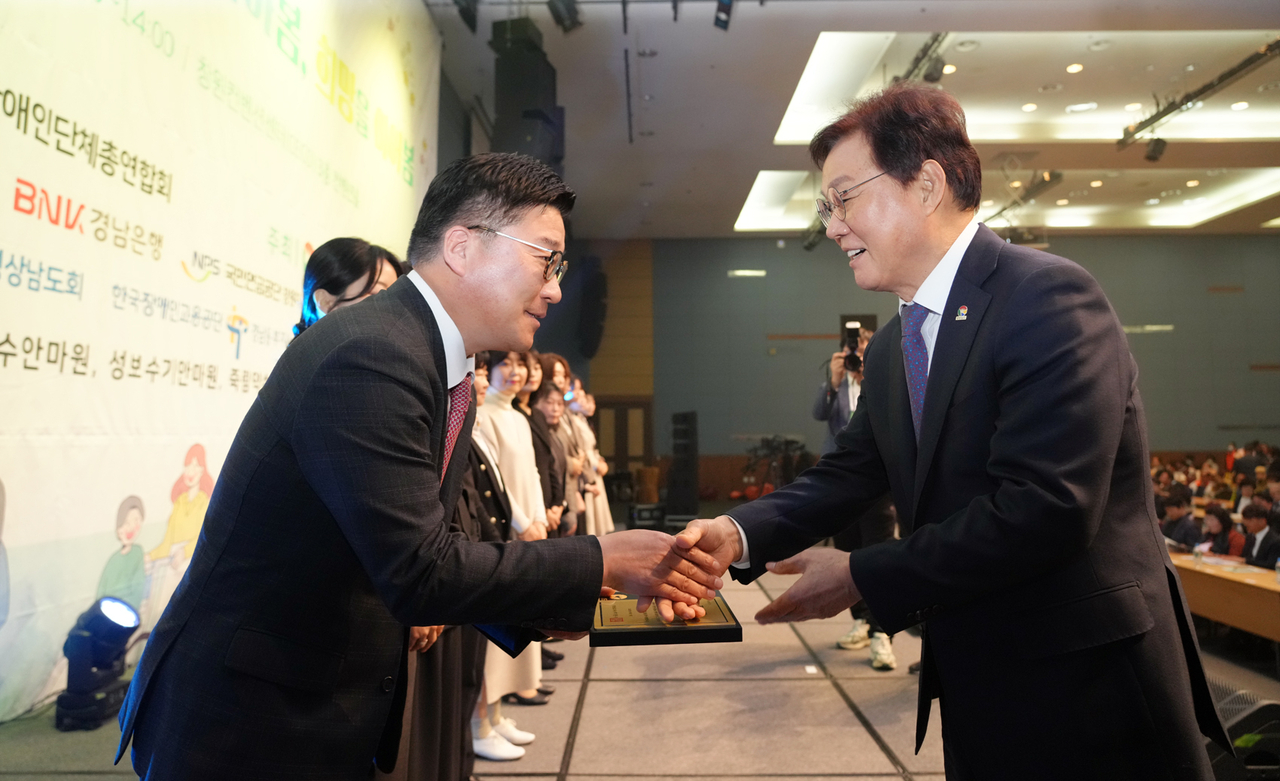 BNK경남은행 허종구(왼쪽) 부행장이 박완수 경남도지사로부터 표창을 받고 있다. [경남은행 제공]