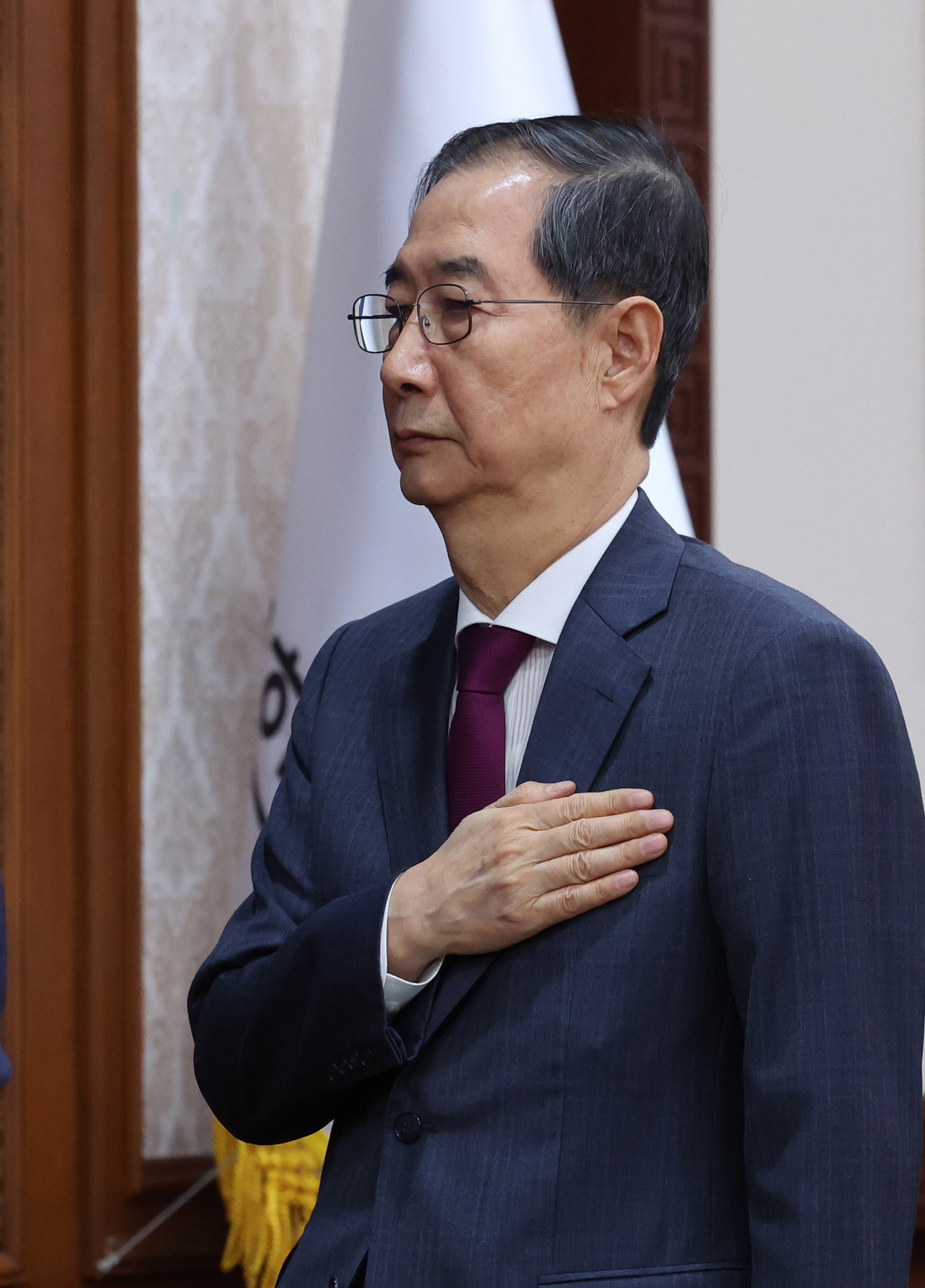 Acting President Han Duck-soo salutes the national flag as he attends a Cabinet meeting in Seoul on Monday. (Pool photo via Yonhap)