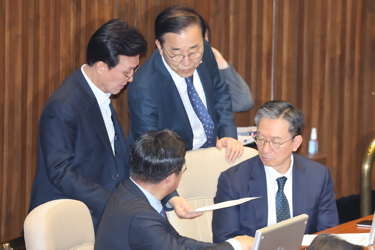 더불어민주당 이재명 전 대표의 좌장 격인 정성호 의원(아래 오른쪽부터 시계방향), 이 대표의 경선캠프 선대위원장인 윤호중 의원, 김민석 최고위원, 김윤덕 사무총장이 14일 국회 본회의장에서 권리당원 투표 관련 문서를 함께 보고 있다. [연합]