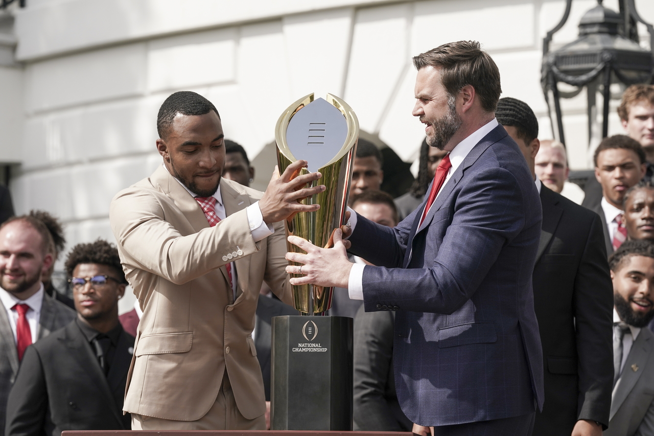 Ohio State University football player TreVeyon Henderson (left) and US Vice President JD Vance (right) reassemble the national football championship trophy after Vance dropped it, during a ceremony honoring the Ohio State University Buckeyes football team at the White House, in Washington, Monday. (EPA-Yonhap)