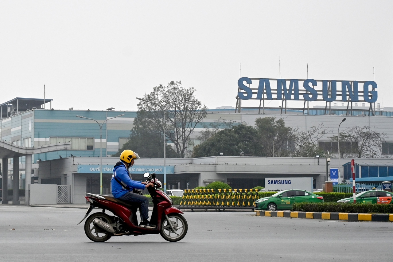 A man rides a motorbike through the entrance gate of Samsung's electronic components factory in Bac Ninh province on April 8. (AFP)