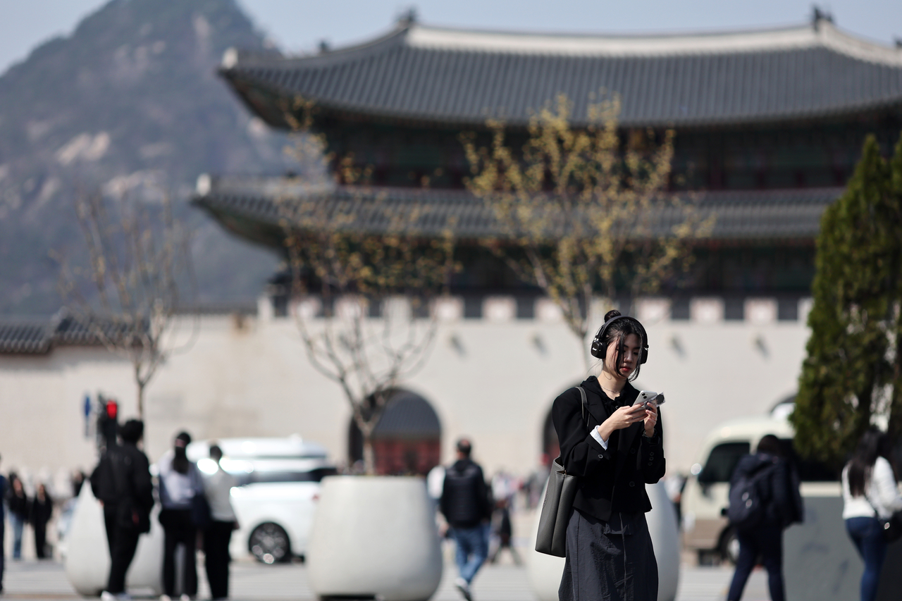 A pedestrian walks by in Gwanghwamun Square, central Seoul, on April 6. (Yonhap)