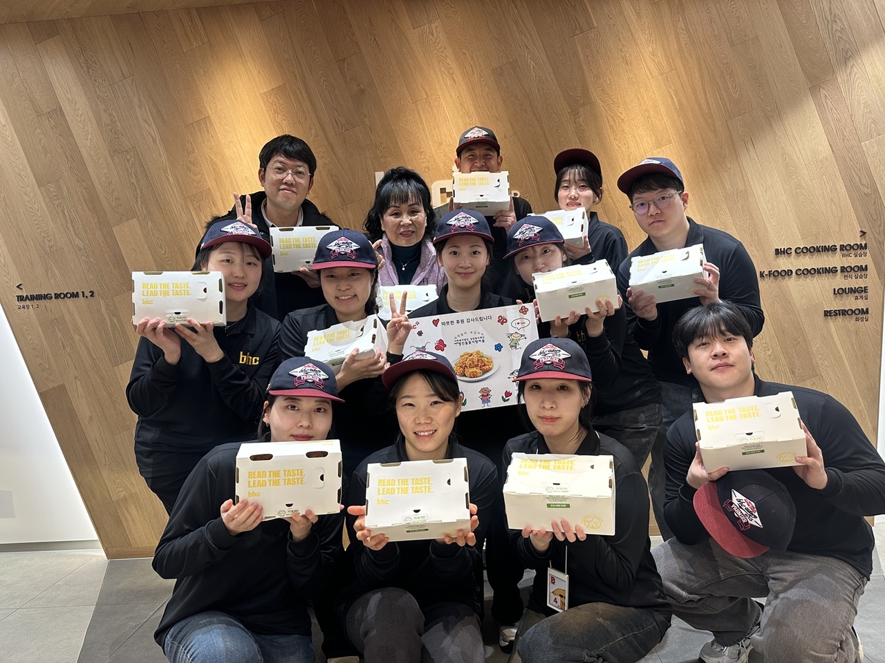 다이닝브랜즈그룹 공채 신입사원이 사회복지시설 관계자에게 치킨을 기부하고 기념 촬영을 하고 있다. [다이닝브랜즈그룹 제공]
