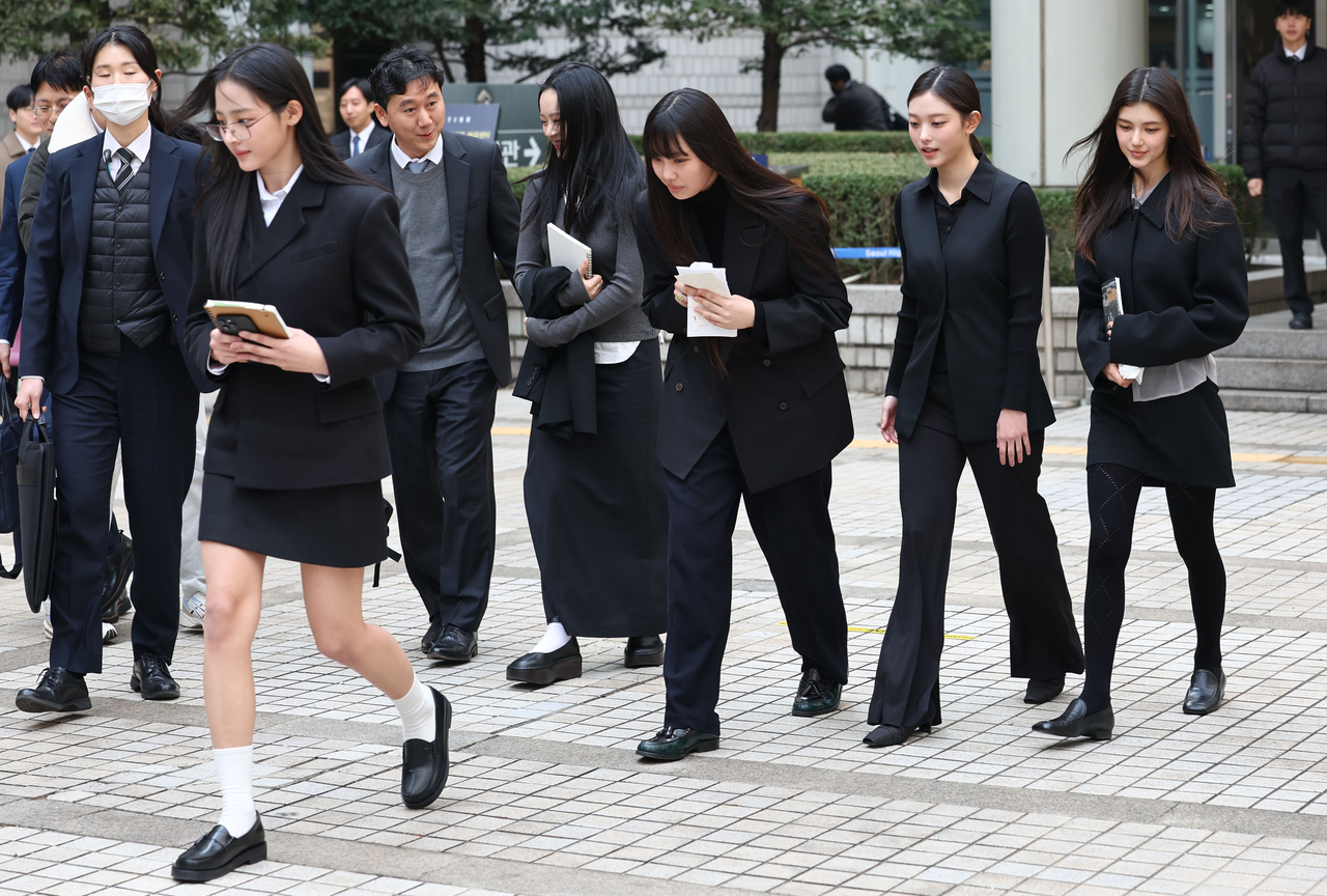 In this file photo, members of K-pop girl group NJZ, formerly NewJeans, walk out after attending a hearing on their agency's request for an injunction banning their independent activities at the Seoul Central District Court in the capital on March 7. (Yonhap)