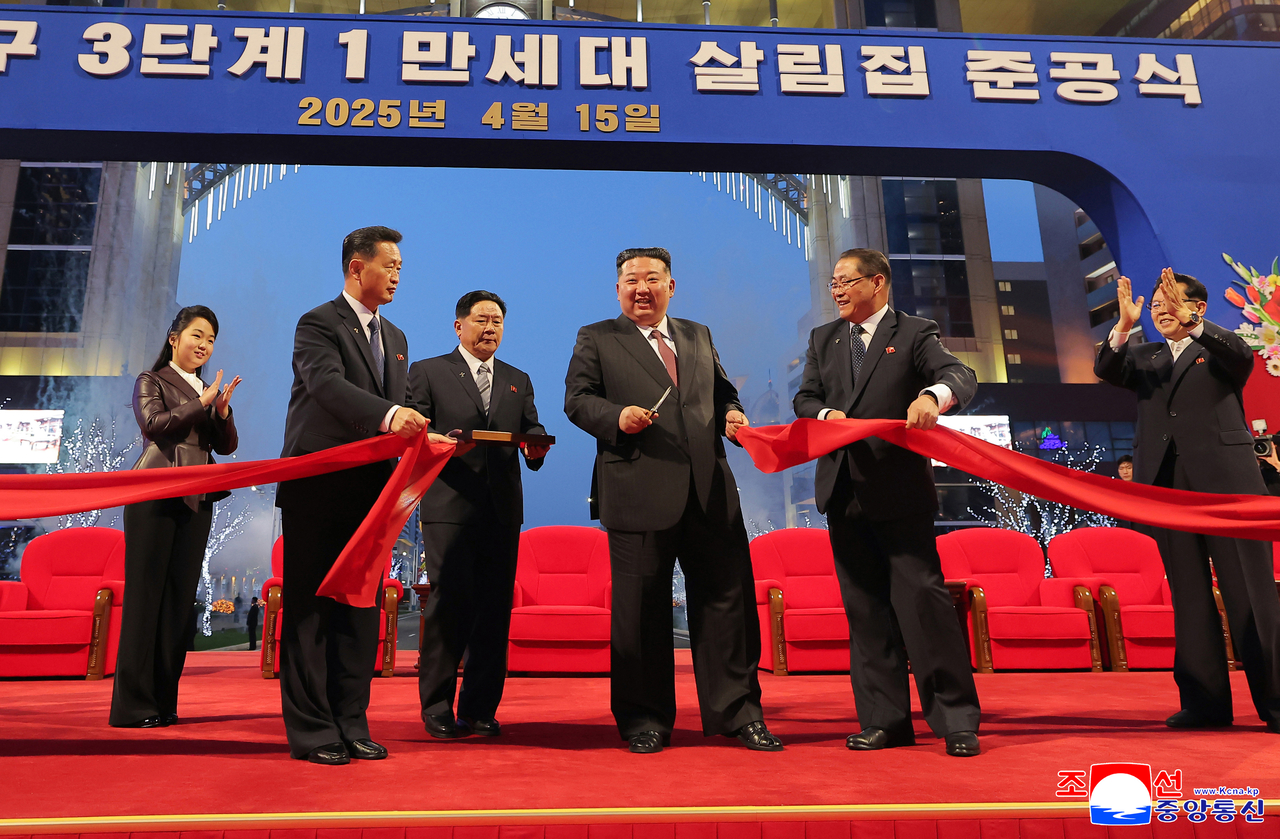 North Korean leader Kim Jong-un (center) cuts the ribbon at a ceremony commemorating the completion of the third-stage section of the Hwasong new town in Pyongyang on Tuesday. (Yonhap)
