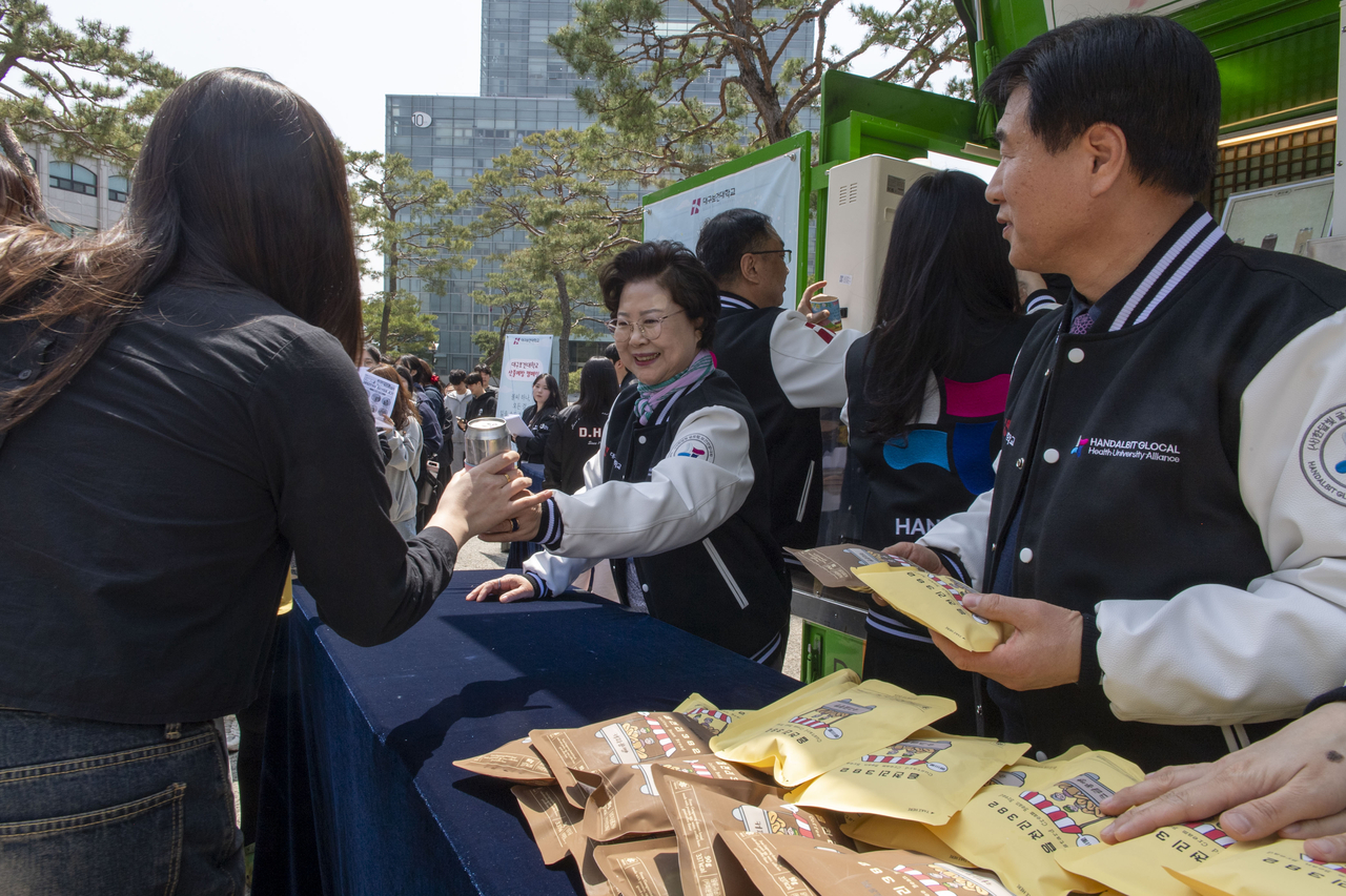 지난 16일 인당아트홀 앞 삼거리에서 ‘글로컬 대구보건대 느좋(느낌 좋은) 재학생’ 커피차 이벤트에서 대구보건대 남성희 총장이 재학생들에게 간식을 나눠주고 있다.[대구보건대 제공]