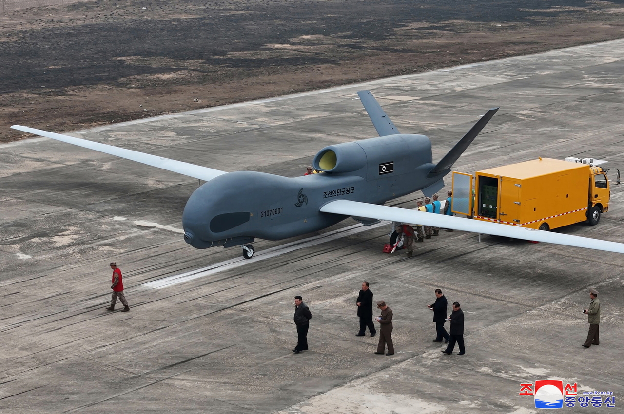 An undated photo released by the official North Korean Central News Agency on 27 March shows North Korean leader Kim Jong Un (second from left) inspecting what appears to be a large reconnaissance drone at an undisclosed location in North Korea. (EPA-Yonhap)