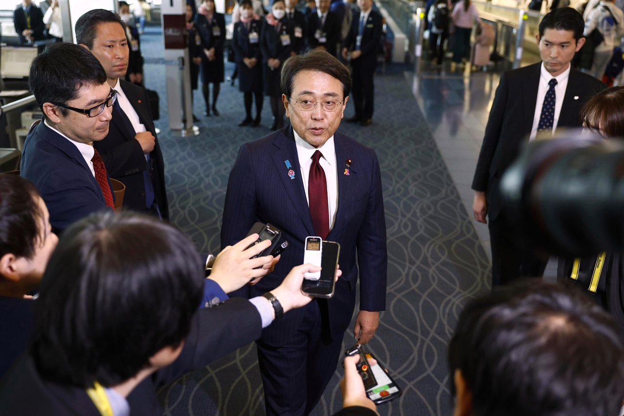 Japan's chief trade negotiator and Economic Revitalization Minister Ryosei Akazawa (center) speaks to the reporters before this departure for the US, at Haneda Airport in Tokyo on Wednesday.   AP-Yonhap