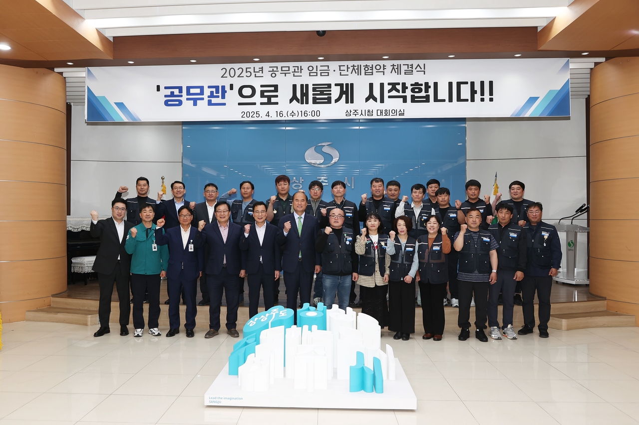상주시와 공무직 지부가 임금 및 단체협약 체결후 단체 기념사진을 찍고 있다.(상주시 제공)