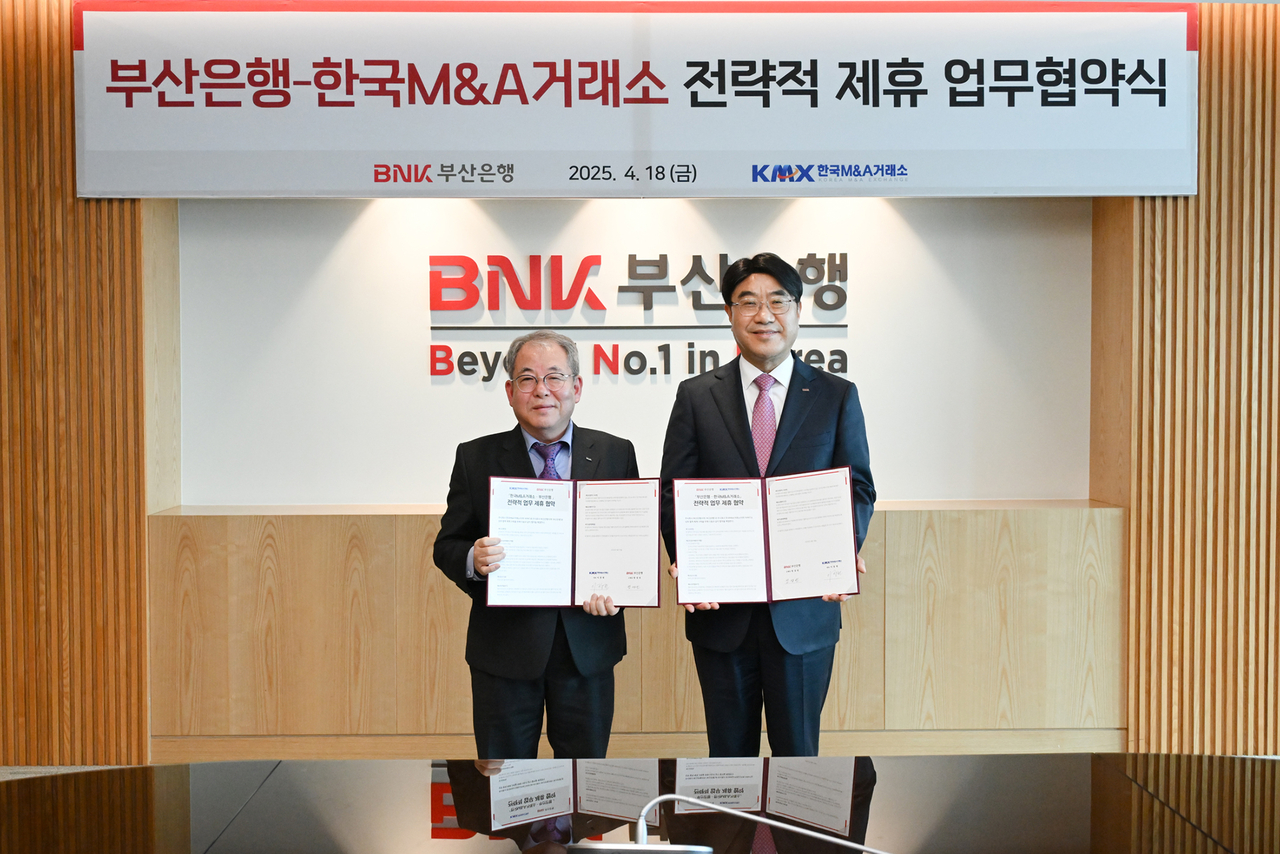 방성빈 BNK부산은행 은행장(오른쪽),  이창헌 한국M&A거래소 회장은 18일 두 기관의 상호 협력체계 구축을 위한 전략적 업무협약(MOU)를 체결한 뒤 기념사진을 촬영하고 있다. [BNK부산은행 제공]