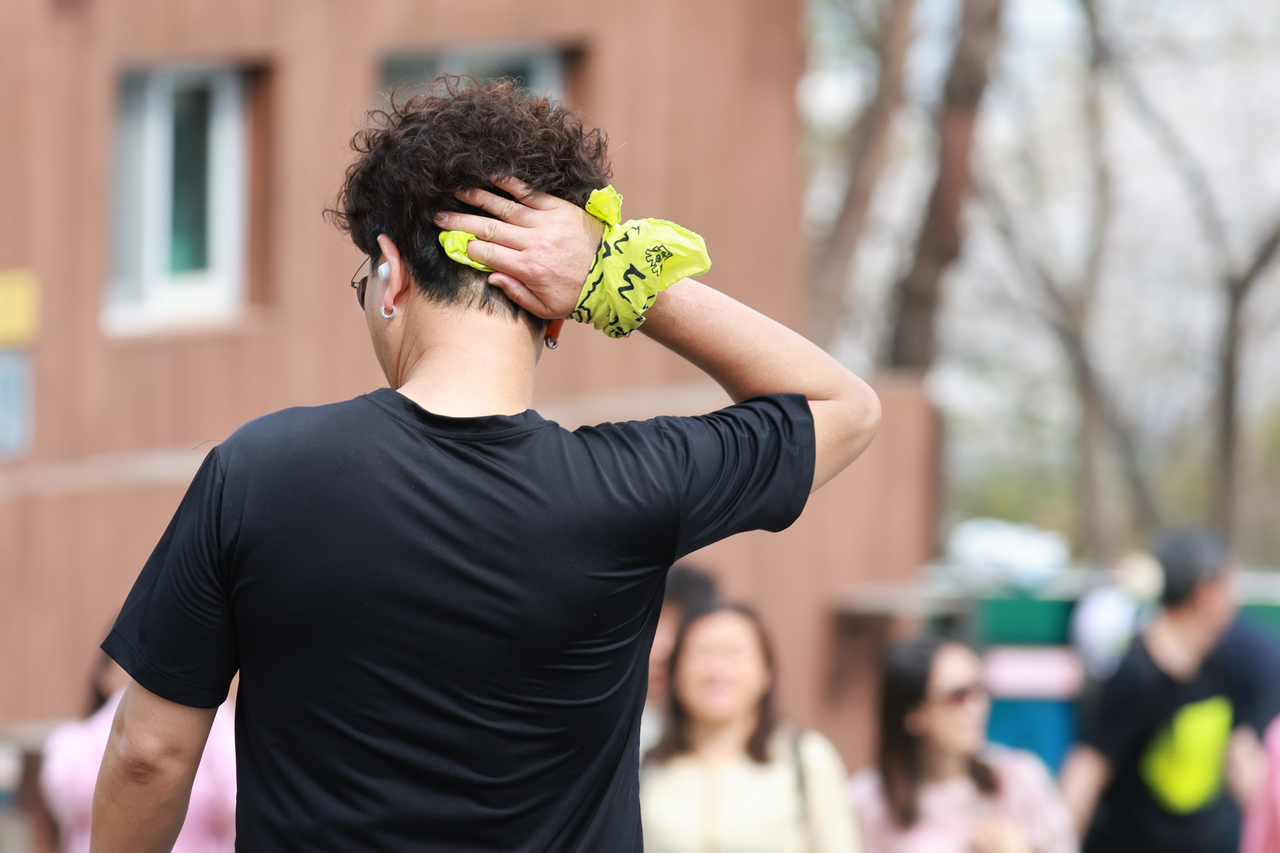 A pedestrian wipes away sweat near Namsan in central Seoul on Thursday. (Yonhap)
