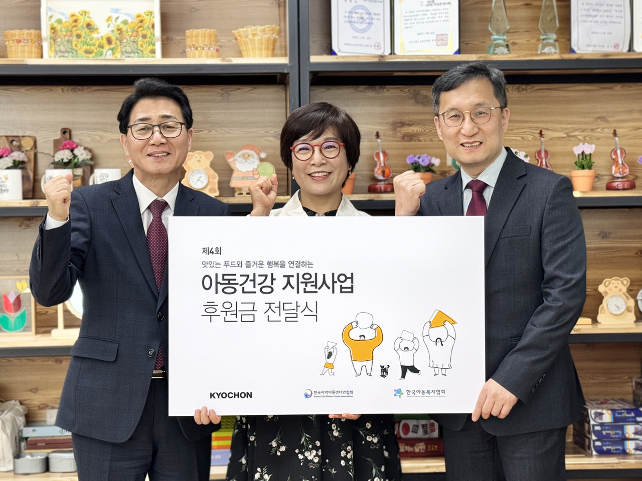 강창동(왼쪽부터) 교촌에프앤비 커뮤니케이션부문장, 장문희 더조은지역아동센터 센터장, 옥경원 한국지역아동센터연합회 대표가 지난 18일 전북 익산시 더조은지역아동센터에서 열린 ‘제4회 아동건강 지원사업’ 전달식에서 기념촬영을 하고 있다. [교촌에프앤비 제공]