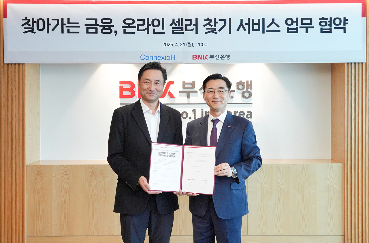 신식 BNK부산은행 개인고객그룹장(오른쪽), 이경호 코넥시오에이치㈜ 대표이사는 21일 온라인 셀러 찾기 서비스 업무 협약을 맺고 기념사진을 촬영하고 있다. [BNK부산은행 제공]