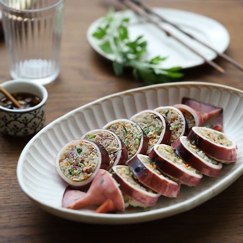 Steamed Korean sundae blood sausage sliced on a wooden serving board, a classic Korean street food snack