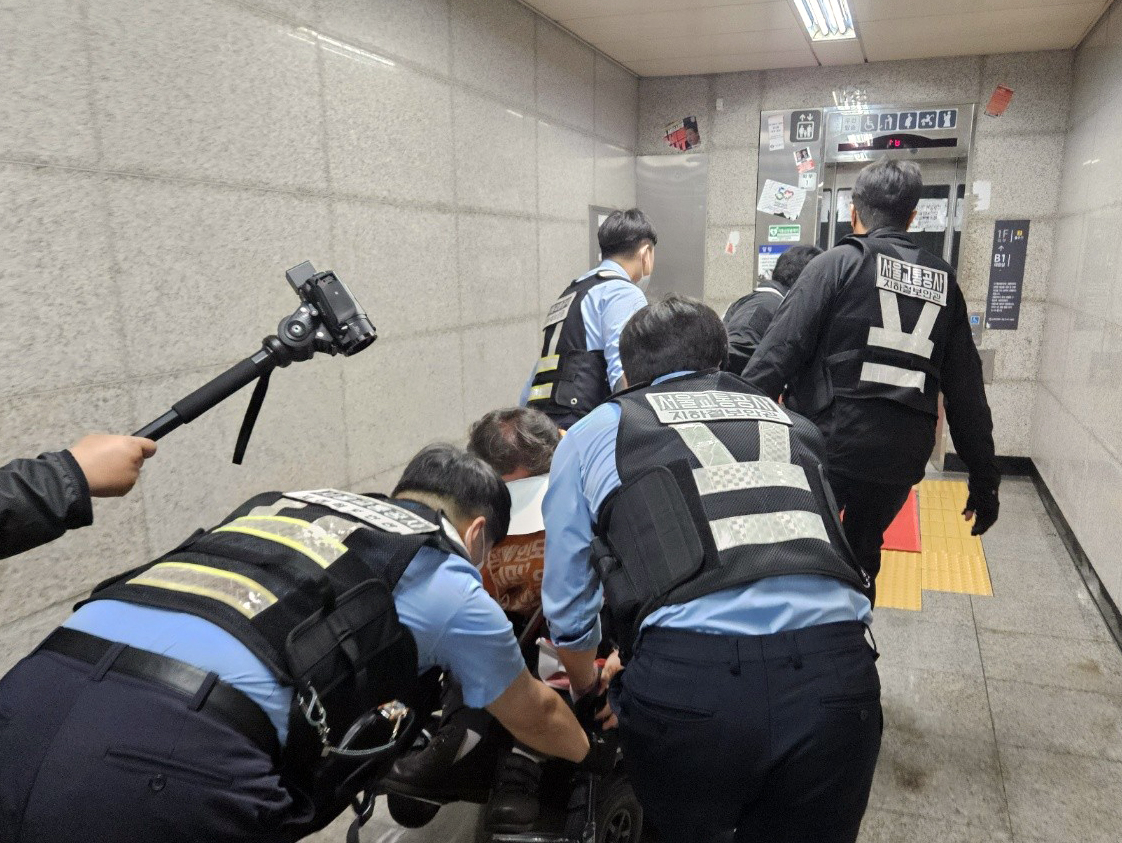 22일 오전 서울 혜화역 승강장에서 선전전을 벌이던 전국장애인차별철폐연대(전장연) 회원이 서울교통공사 지하철보안관들에 의해 강제 퇴거당하고 있다. [연합뉴스]