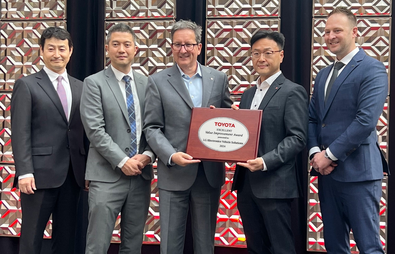 Oh Hae-jin (second from right), president of LG Electronics Vehicle Solution Co. USA, and Pablo Zambrano (center), senior sales director at LG Electronics, hold a plaque recognizing LG's collaboration with Toyota’s North American production, during the award ceremony held in Detroit. (LG Electronics)