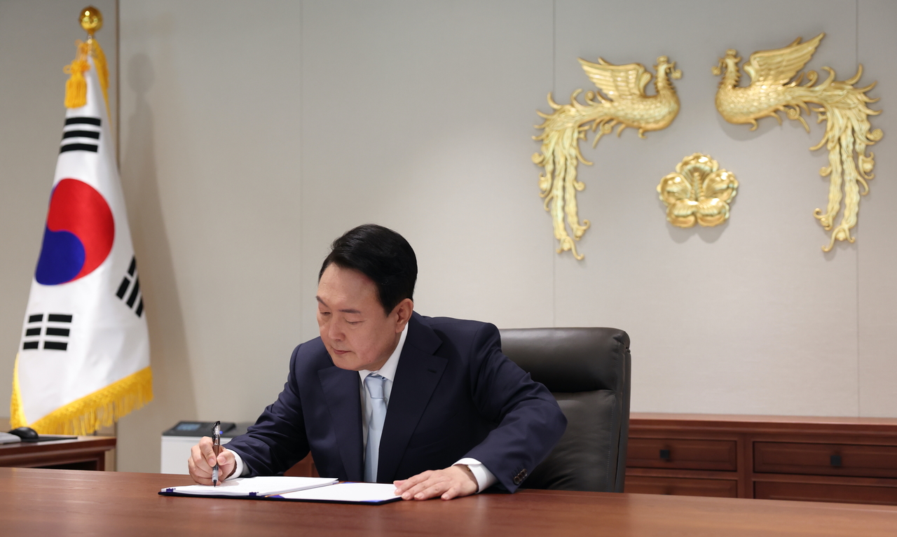 Former President Yoon Suk Yeol signs his first bill as the head of state on May 10, 2022. (Presidential office)