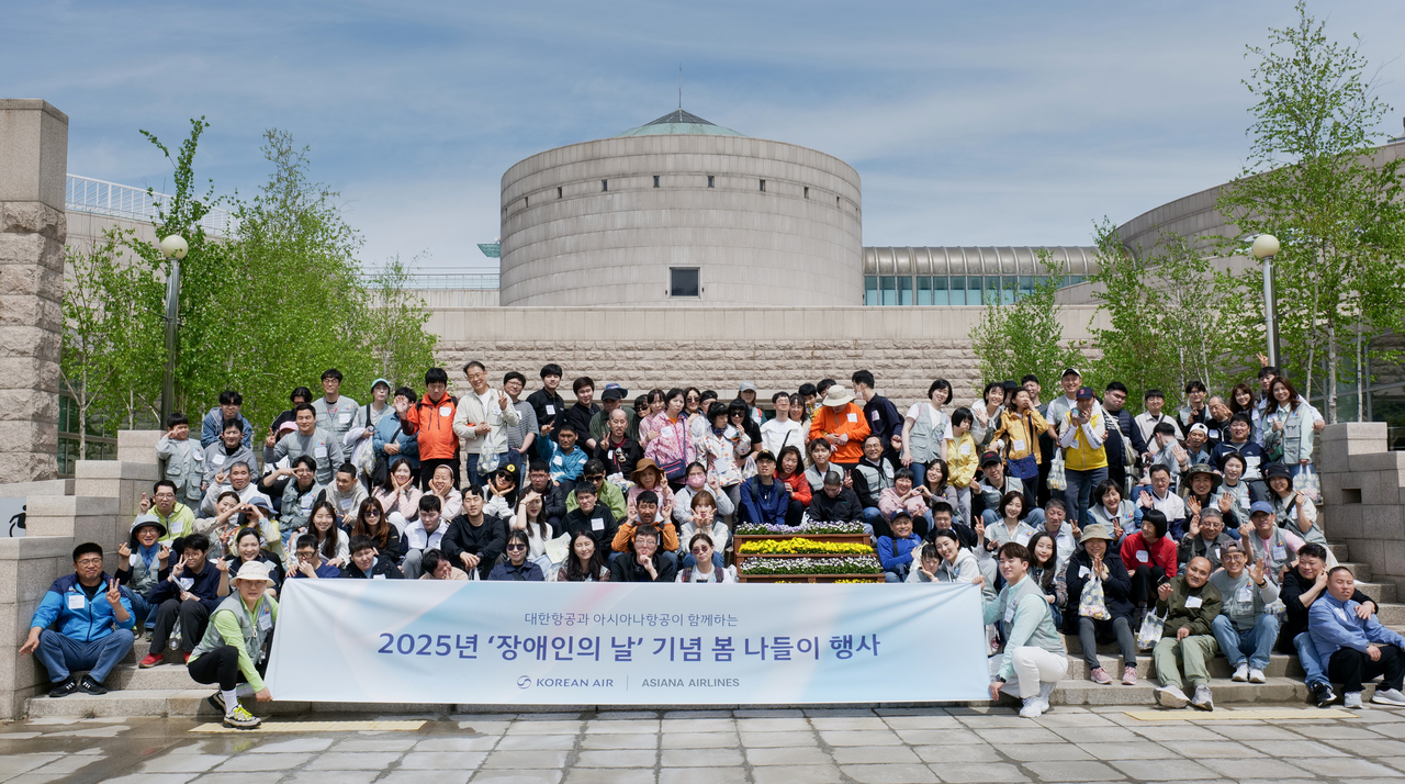 ‘2025 장애인의 날’을 맞아 장애인 단체 대상 나들이 지원 봉사활동에 참여한 대한항공과 아시아나항공 임직원들이 기념촬영을 하고 있다. [대한항공 제공]