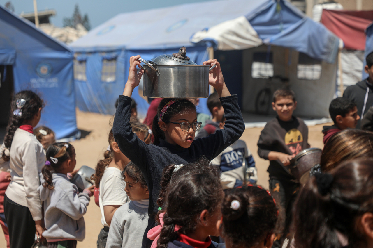 Palestinian children wait to receive free food from a food distribution center in Gaza City, Sunday.   (Xinhua-Yonhap)