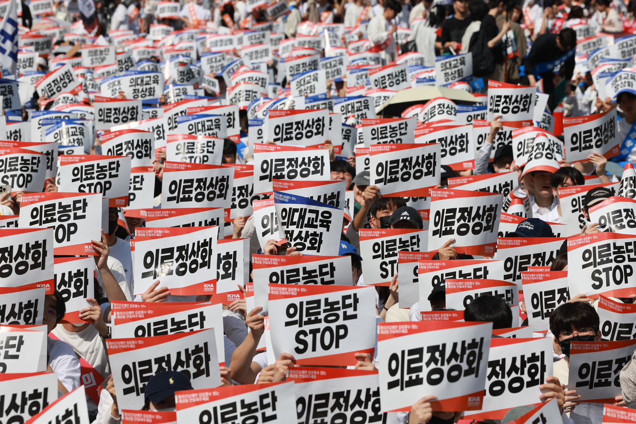 20일 서울 중구 숭례문 인근 세종대로에서 대한의사협회가 연 ‘의료정상화를 위한 전국의사궐기대회’ 참가자들이 정부의 의대 증원 정책과 의료개혁특별위원회 운영 등을 규탄하며 구호를 외치고 있다. [연합]