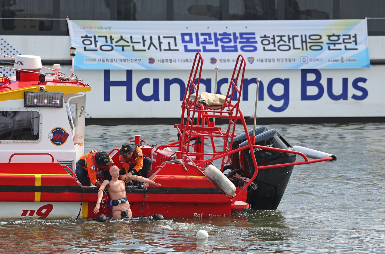 Officials conduct a rescue drill simulating a fire aboard a Hangang River Water Bus on Wednesday. (Yonhap)