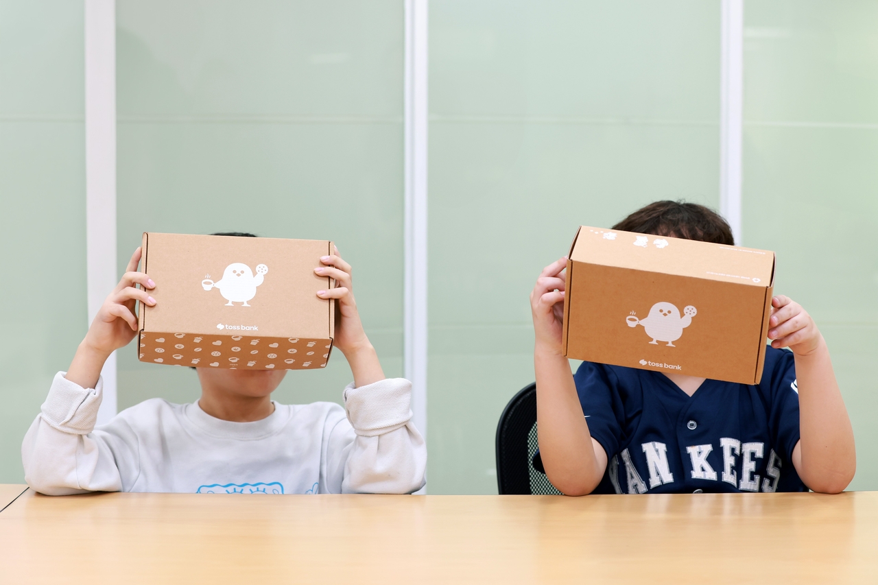 가정폭력쉼터 아이들이 ‘토스뱅크 응원키트’를 들고 있다. [토스뱅크 제공]