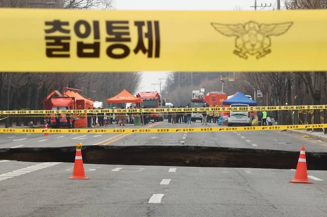 지난달 25일 서울 강동구 명일동 도로에서 전날 발생한 싱크홀 현장에 소방의 출입통제 라인이 설치돼 있다.[연합]