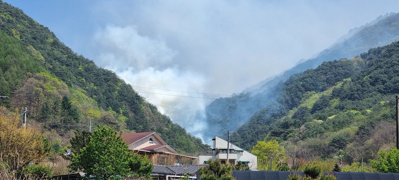 Smoke rises from a wildfire in Inje County, Gangwon Province, South Korea, on Saturday afternoon, forcing evacuations and closing parts of the Seoul-Yangyang Expressway. (Korea Forest Service)