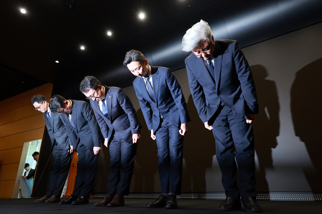 SK Telecom CEO Ryu Young-sang (center) and other senior executives bow in apology over the recent hacking incident during a press conference at the company's headquarters in Seoul on Friday. (Yonhap)