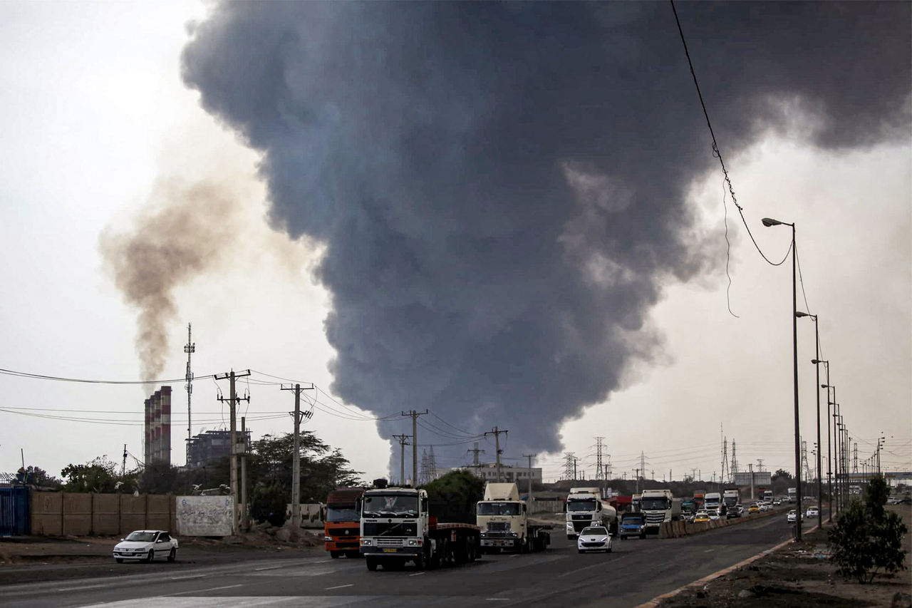 A thick plume of smoke billows as motorists drive their vehicles along a highway near the source of an explosion at the Shahid Rajaee port dock southwest of Bandar Abbas, in the Iranian province of Hormozgan, Saturday. (AFP-Yonhap)