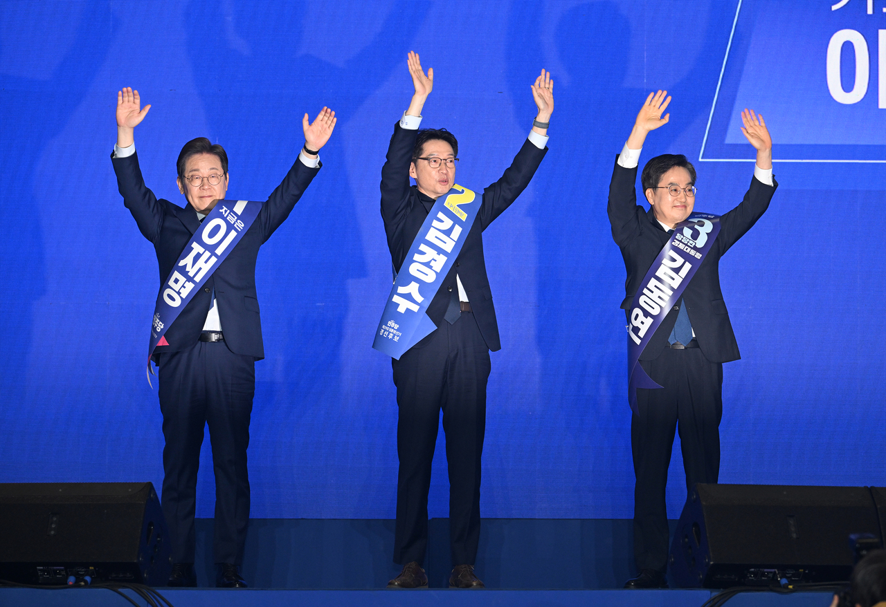 The three Democratic Party of Korea primary contenders wave to a crowd of supporters in Ilsan, Gyeonggi Province, on the last day of the party's primaries on Sunday. From left are Lee Jae-myung, Kim Kyung-soo and Kim Dong-yeon. (Yonhap)