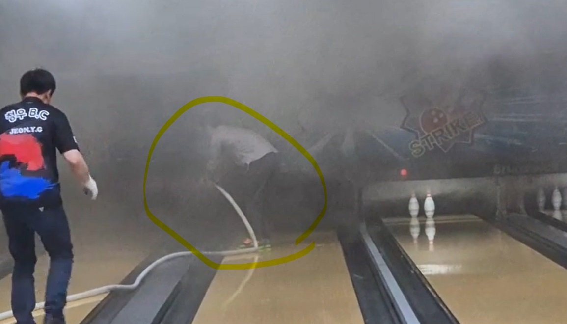 Firefighter Ji Su-ryong (in yellow circle) struggles to contain a fire that broke out at a bowling alley in Incheon on Saturday. (Incheon Fire Service)