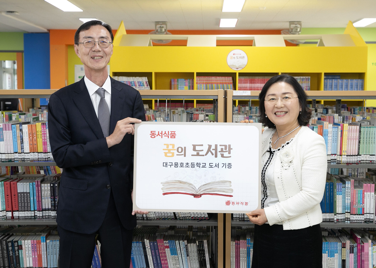 28일 대구용호초등학교에서 진행된 ‘제9회 동서식품 꿈의 도서관’ 도서 기증식에서 최상인(왼쪽) 동서식품 홍보상무와 권명숙 대구용호초 교장이 기념사진을 촬영하고 있다. [동서식품 제공]