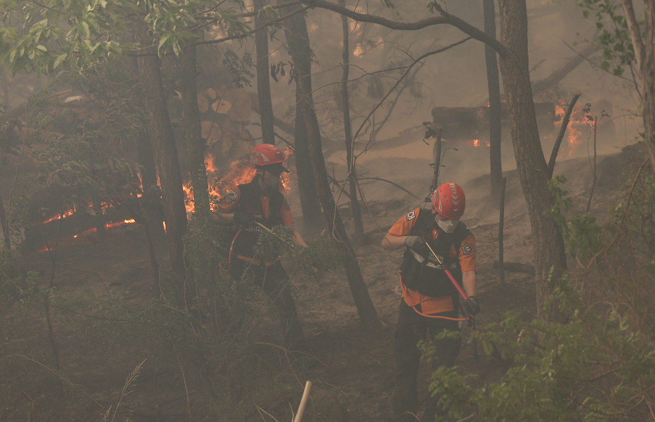 Firefighters make efforts to contain wildfire at Hamjisan in Daegu on Monday. (Yonhap)