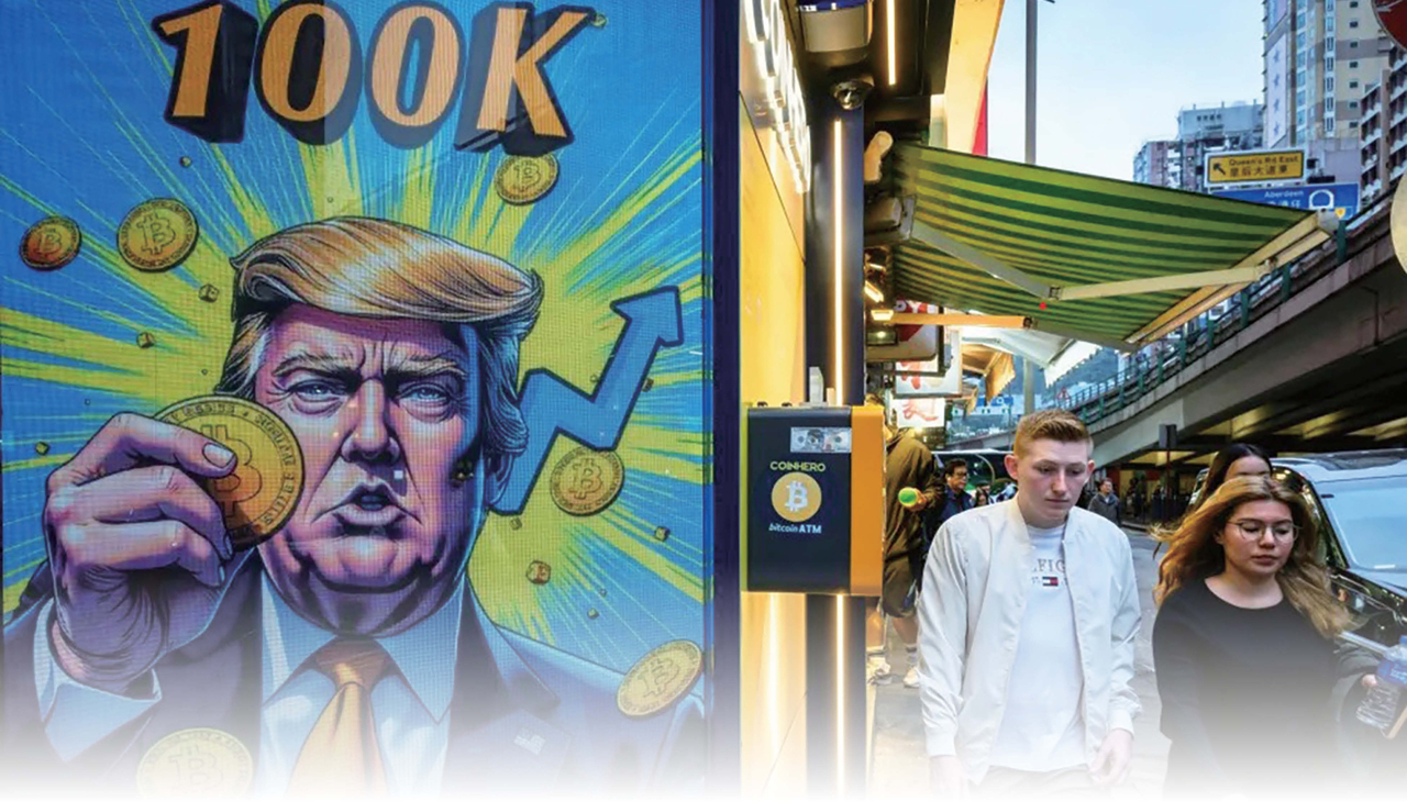 2025년 3월 12일 암호화폐 코인을 들고 있는 도널드 트럼프 대통령 화면이 있는 홍콩의 암호화폐 거래소 사무실 앞을 사람들이 지나가고 있다 [AFP/게티이미지]