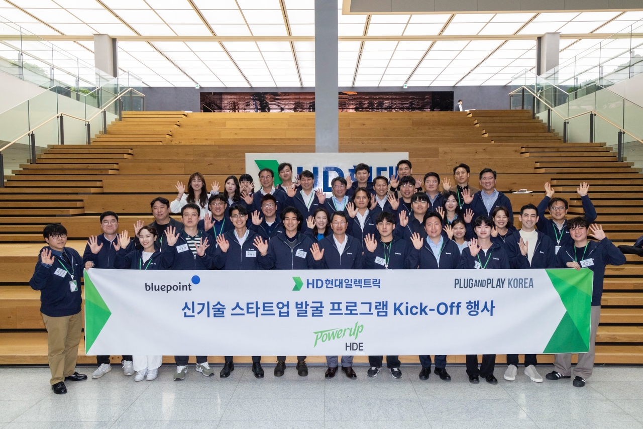 HD Hyundai Electric CEO Kim Young-ki (front row, seventh from left) poses with officials from HD Hyundai, Bluepoint and Plug and Play at the launch ceremony for the startup support program, held Monday at HD Hyundai’s headquarters in Seongnam, Gyeonggi Province. (HD Hyundai)
