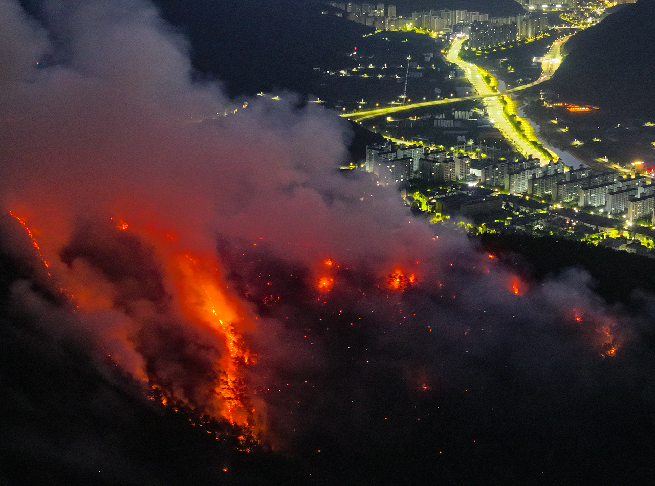 Flames in Hamjisan are seen spreading toward a residential village in Buk-gu, Daegu, before dawn on Tuesday. (Yonhap)