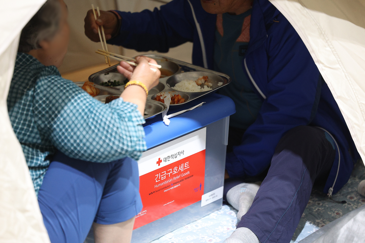 Daegu residents eat breakfast at a shelter set up at Daegu Paldal Elementary School in Buk-gu, Daegu, Tuesday, the second day of the wildfire.  (Yonhap)