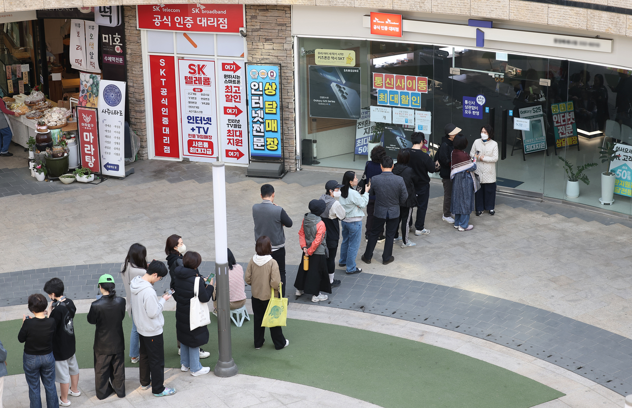 가입자 유심(USIM) 정보를 탈취당한 SK텔레콤이 유심 무료교체 서비스를 시작한 지 이틀째인 29일 서울 시내 한 SKT 대리점에 시민들이 줄을 서서 교체를 기다리고 있다. [연합]