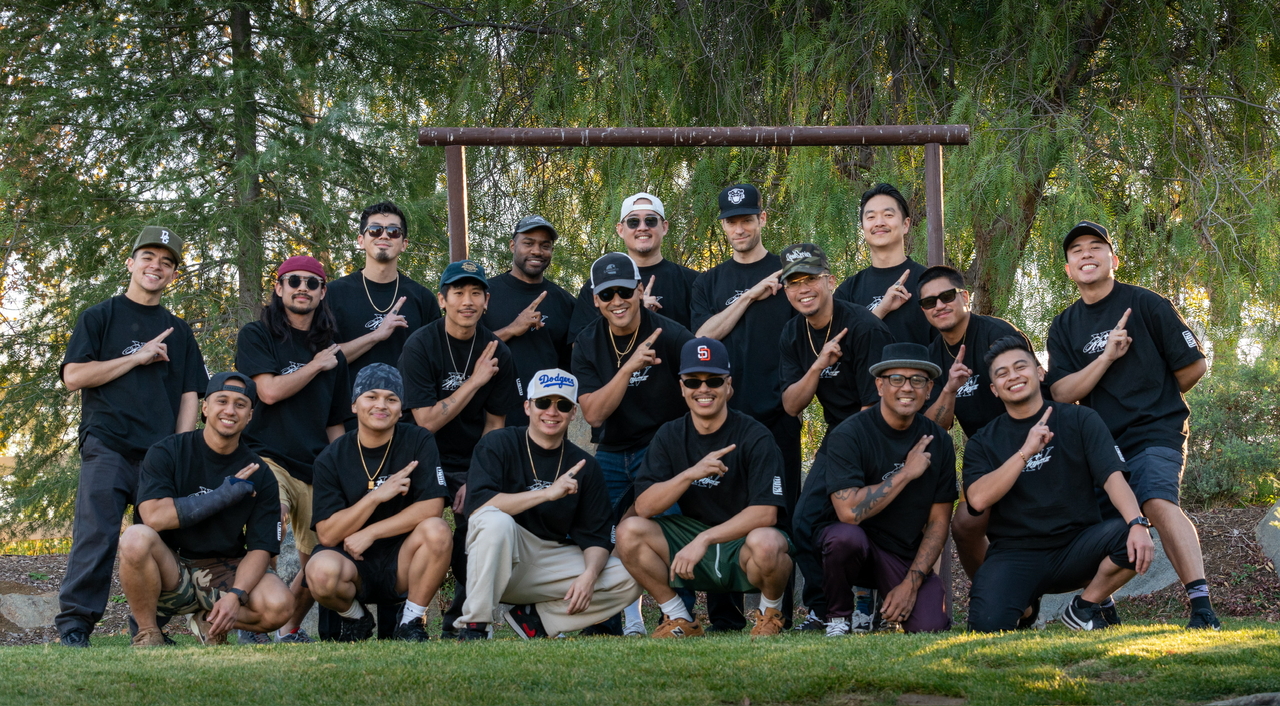 Members of Kinjaz pose with their signature hand sign during a group photo at their 15-year anniversary retreat. (Courtesy of Kinjaz)
