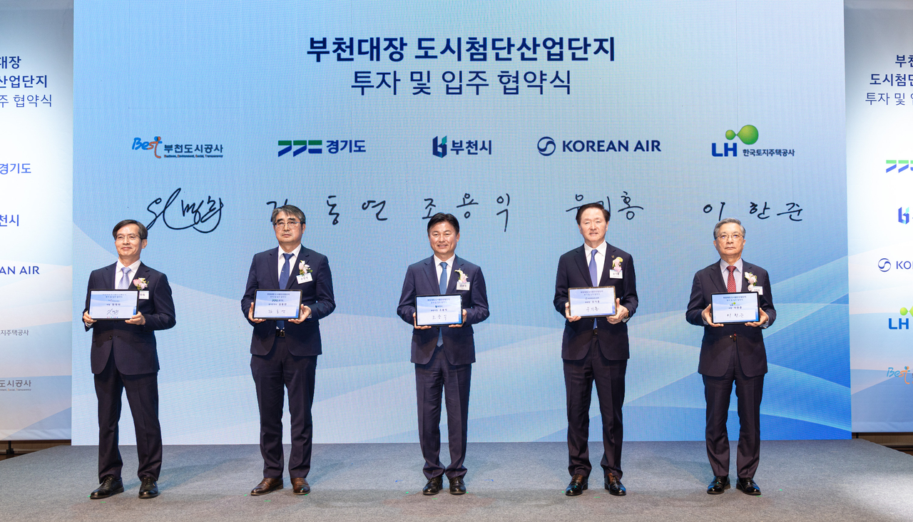 대한항공은 30일 부천아트센터 소공연장에서 부천시와 ‘도심항공교통 및 항공안전 연구개발 단지’ 조성 협약을 체결했다.협약식에 참석한 대한항공 우기홍 부회장(오른쪽 두번째), 조용익 부천시장(오른쪽 세번째), 이한준 한국토지주택공사(LH) 사장(오른쪽 첫번째), 원명희 부천도시공사 사장(오른쪽 다섯번째), 손임성 경기도 도시주택실장(오른쪽 네번째)이 기념촬영을 하고 있다. [대한항공 제공]