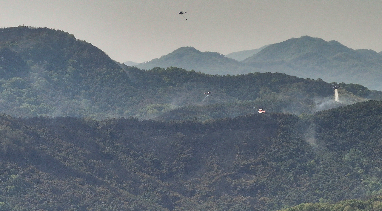 Helicopters attempt to extinguish the remaining wildfires in the southeastern city of Daegu on Tuesday. (Yonhap)