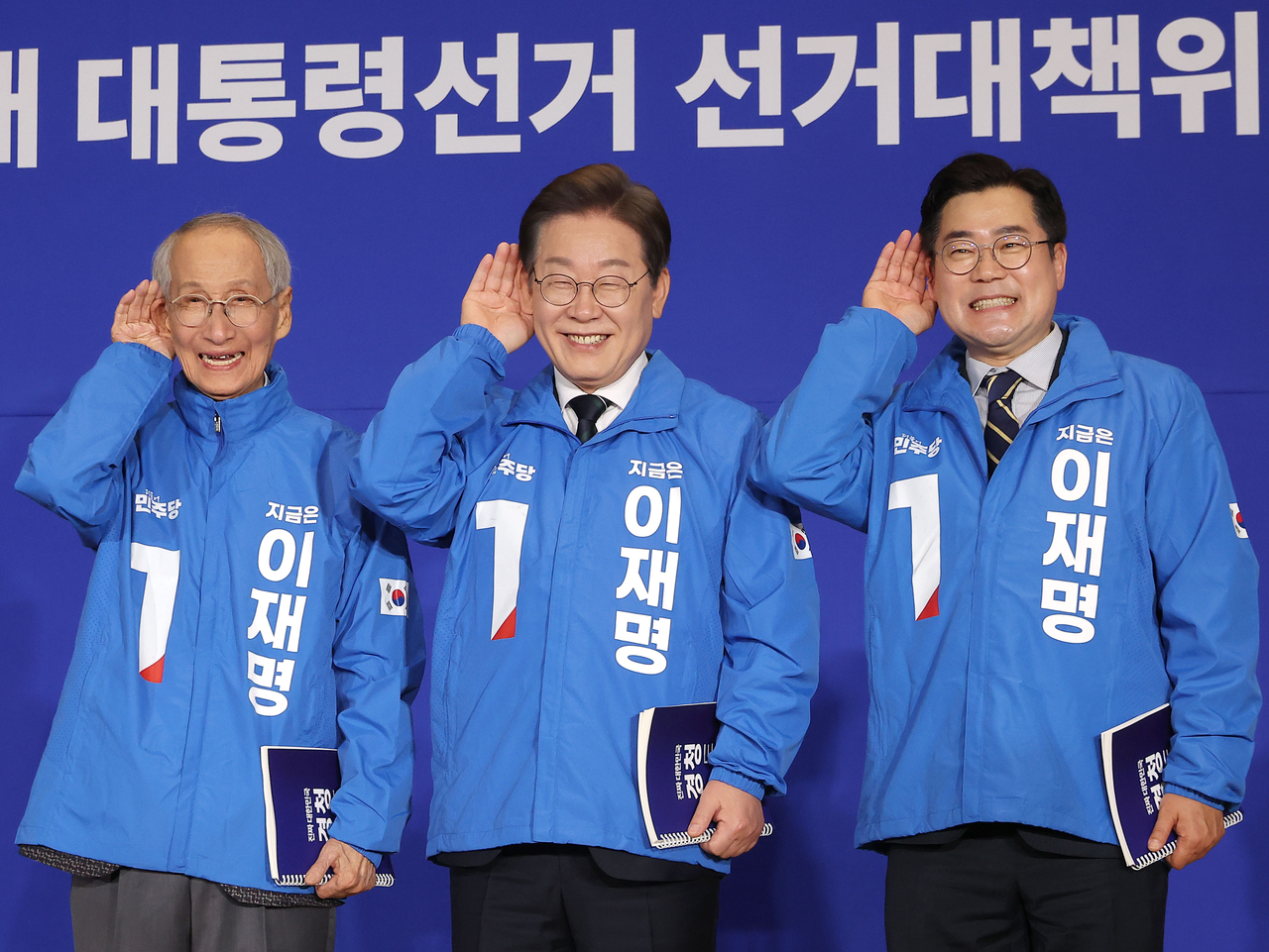30일 서울 여의도 국회 의원회관에서 열린 더불어민주당 제21대 대통령선거 ‘진짜 대한민국’ 중앙선거대책위원회 출범식에서 이재명 대선 후보와 윤여준·박찬대 상임총괄선대위원장이 국민의 목소리에 귀를 기울이겠다는 의미의 ‘경청 퍼포먼스’를 하고 있다. [연합]
