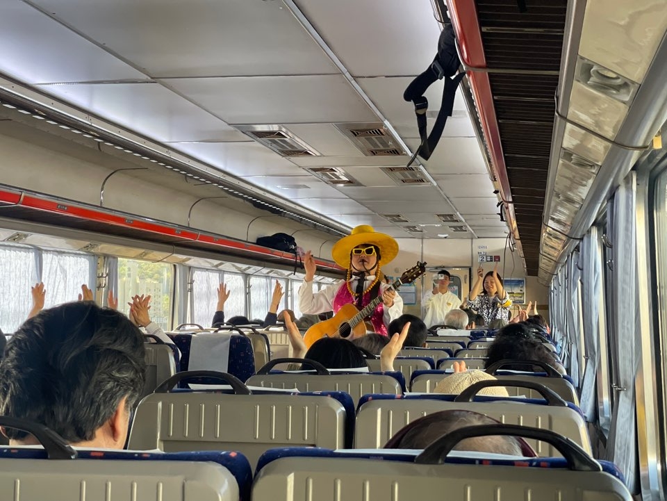 Mr. Got plays guitar and sings in the aisle of the Retro Romantic Train Tour. (Hong Yoo/The Korea Herald)