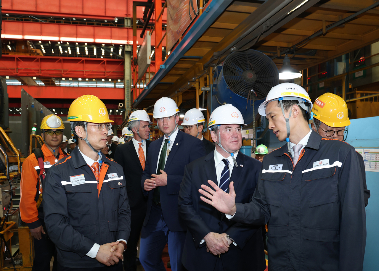 US Navy Secretary John Phelan (third from right) and Hanwha Group Vice Chair Kim Dong-kwan (second from right) engage in discussions during Phelan‘s visit to Hanwha Ocean’s ship block manufacturing plant in Geoje, South Gyeongsang Province, on Wednesday.  (Hanwha Ocean)