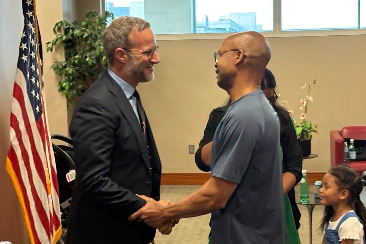 Adam Boehler (left), the Trump administration's top envoy for hostage affairs, greets military contractor Tony Holden, who was recently released from Kuwait, in Chantilly, Virginia, Wednesday. (AP-Yonhap)