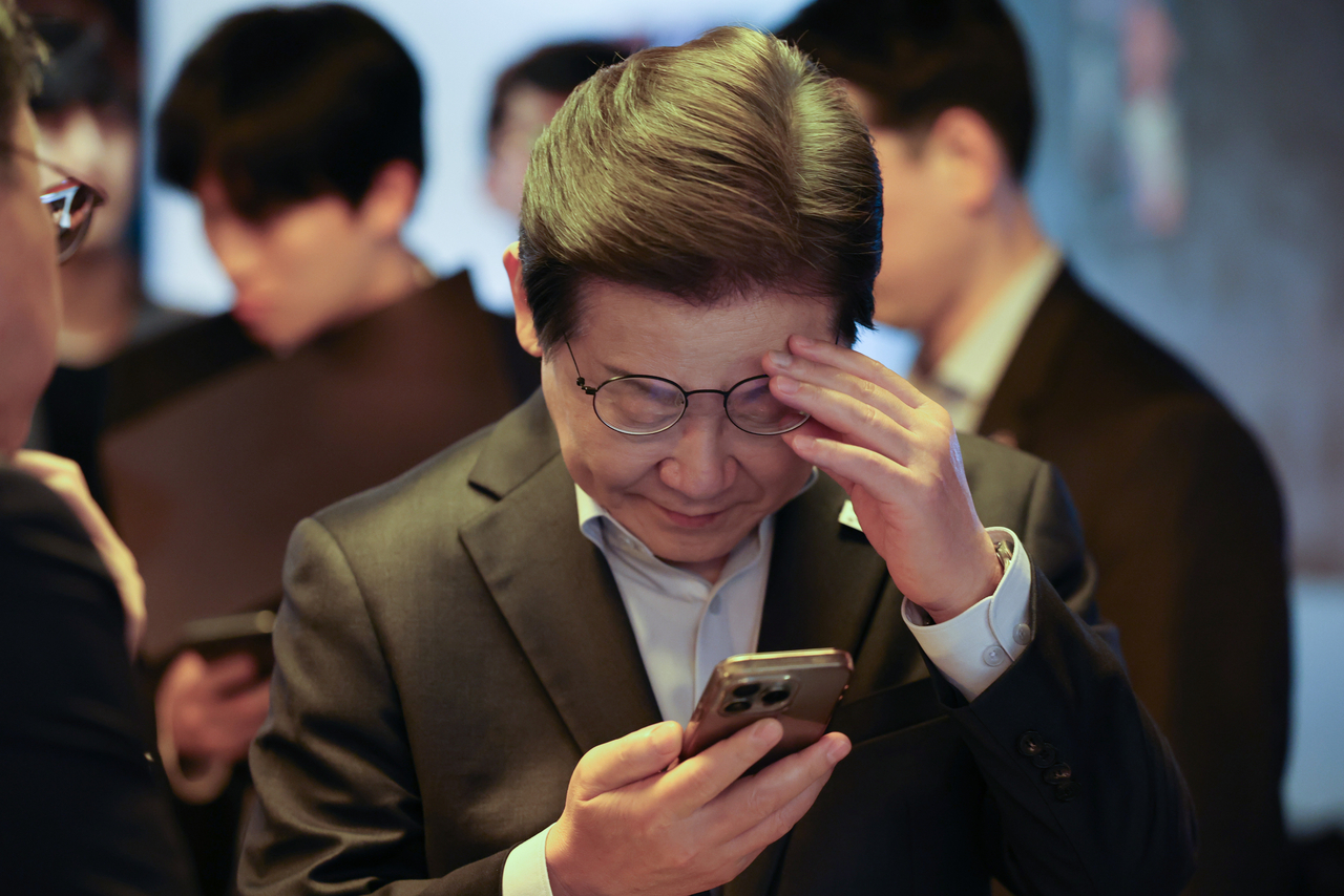 더불어민주당 이재명 대선 후보가 1일 서울 종로구의 한 포차 식당에서 ‘당신의 하루를 만드는, 보이지 않는 영웅들’이란 주제로 열린 배달 라이더, 택배 기사 등 비(非)전형 노동자들과의 간담회를 마친 뒤 스마트폰을 확인하고 있다. [연합]