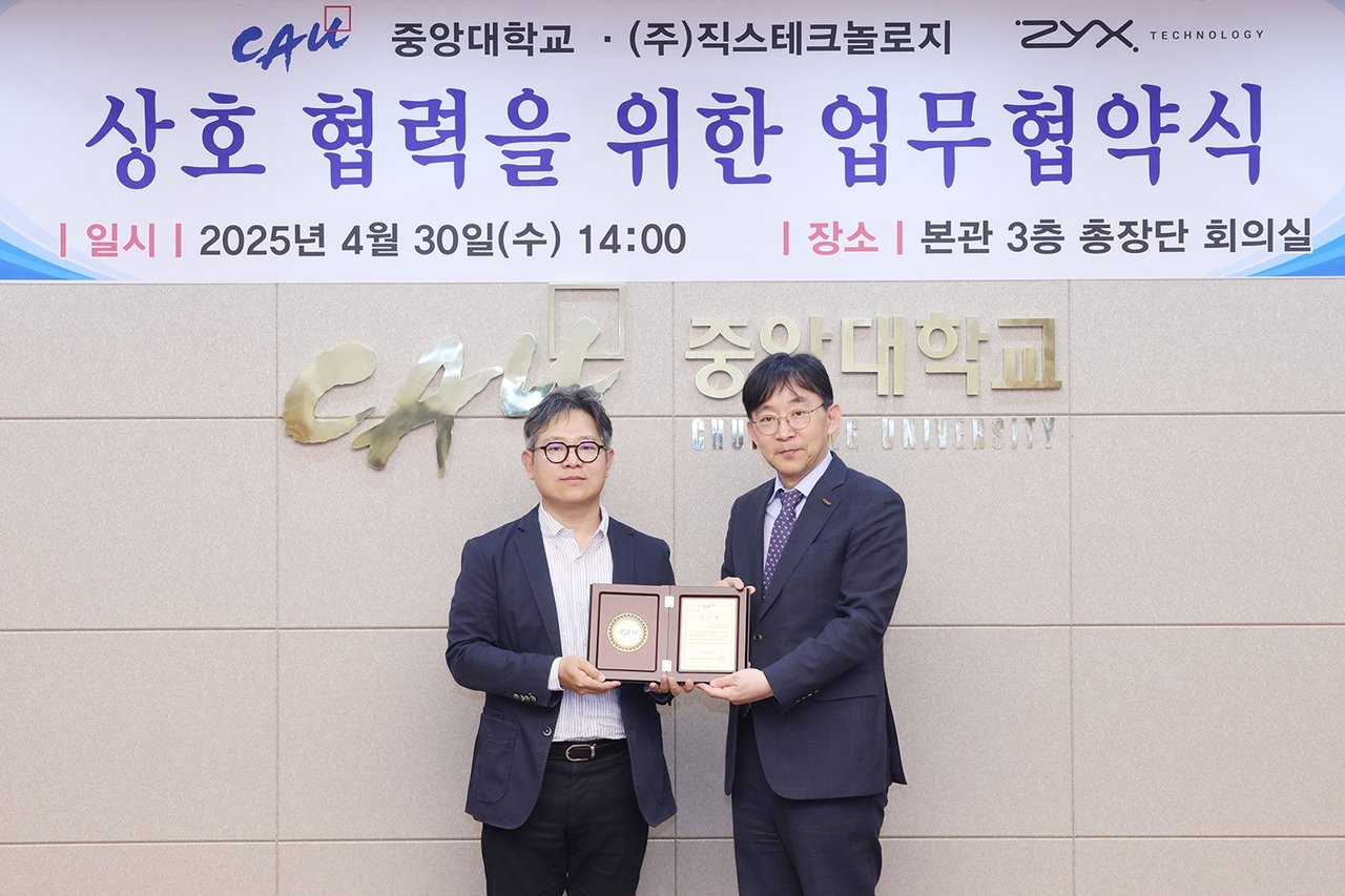 Eom Shin-jo (left), CEO of Zyx Technology, and Park Sang-gue, president of Chung-Ang University, pose for a photo at an MOU signing ceremony at Chung-Ang University in Seoul on Wednesday. (Zyx Technology)