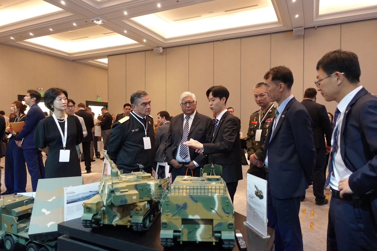Employees of Hanwha Aerospace explain its defense solutions to Chilean military officials at Korea Defense Day 2025 on Monday held in Santiago, Chile. (Hanwha Aerospace)