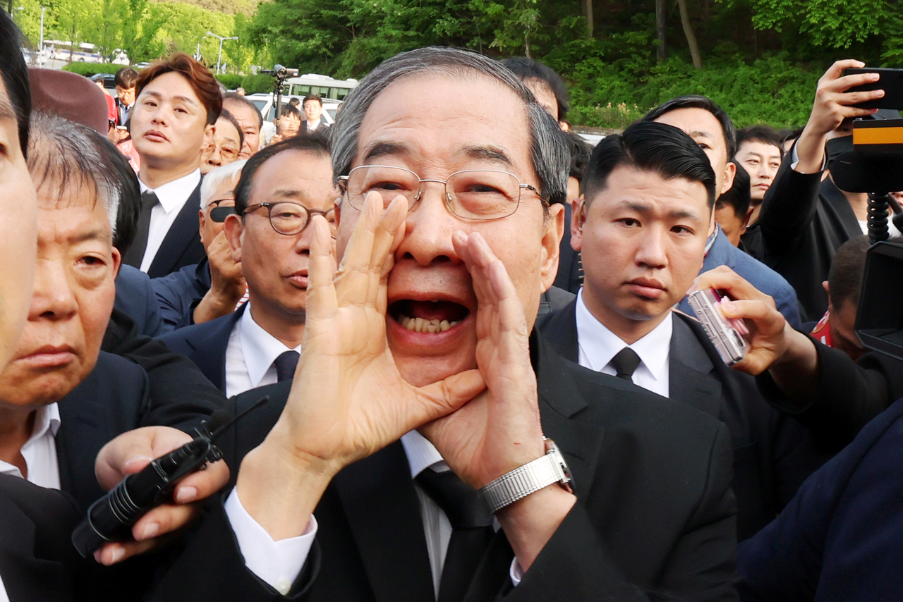 2일 오후 광주 북구 국립 5·18 민주묘지를 찾은 한덕수 전 총리가 광주비상행동 등 시민·사회단체 관계자들의 반발에 가로 막히자 “저도 호남 사람”이라며 참배를 호소하고 있다. [연합]